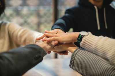 shallow focus photography of five people holding each other hands